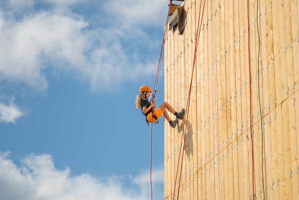 A girl abseils down a wall at Gone Wild festival